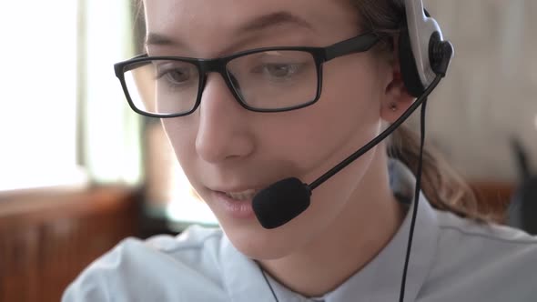 A Girl in Headphones with a Headset Conducts Consultations