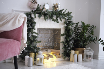 cozy corner with a fireplace decorated with Christmas decorations. Fireplace in room with Christmas