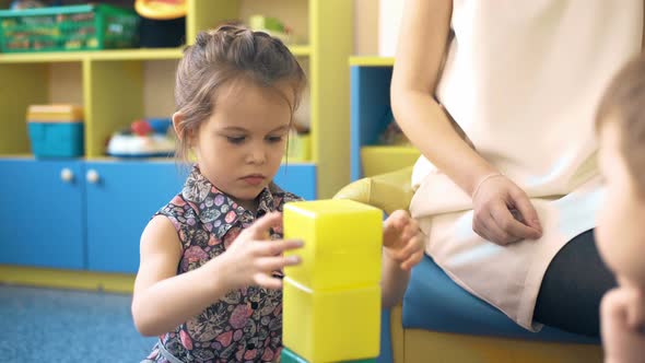 Toddler Girl Build Tower of Colorful Plastic Blocks