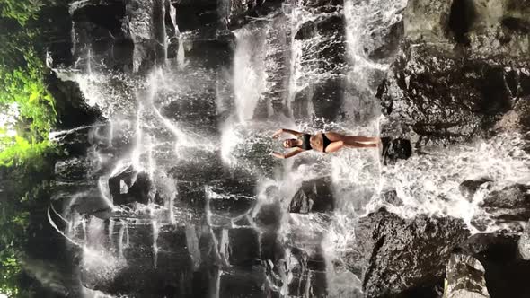Beautiful Lady Female with Beautiful Body Standing on a Rock Under Waterfall Kanto Lampo Bali