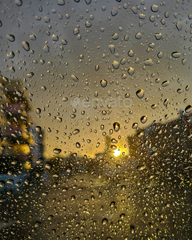Raindrops on glass window at sunset. Wait rainy window