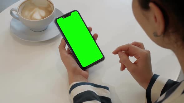 A Woman Is Talking To a Friend Over a Video Call on a Green-screen Smartphone