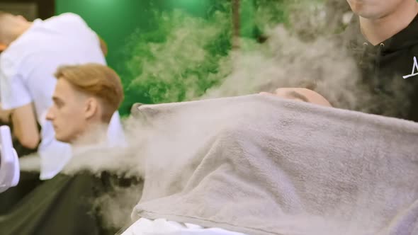 Barber Covers Client with Towel Sitting Against Humidifier