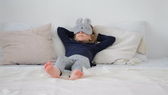 Cute Little Girl Lounging in the Bed at Home