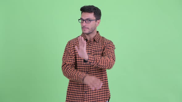 Serious Young Hispanic Hipster Man Showing Stop Gesture