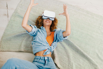 Smiling Woman Enjoying Virtual Reality Game on Sofa at Home