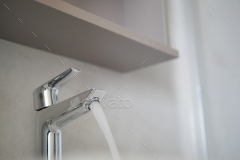 Water dripping from faucet tap at kitchen. Closeup