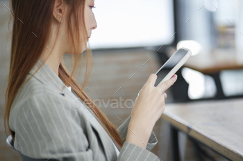 Businesswoman Checking Mobile Device in Office