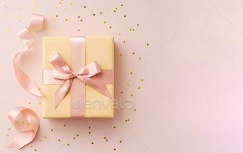A pink giftbox with a pastel yellow bow on a pink.