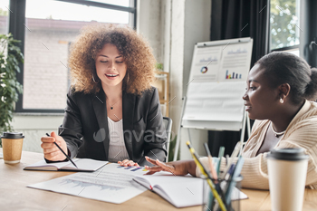 interracial businesswoman working with business analytics and discussing business project in office