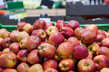 Red and yellow apples in the boxes in big grocery store. ripe apples