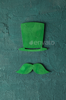 Green hat and mustache on green background, top view