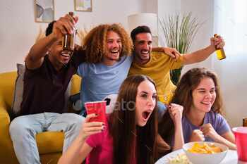 Young friends celebrates a goal watching the football match on TV.