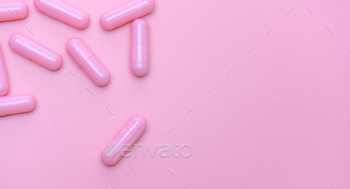 Top view of pink capsule on pink background with copy space. Pharmacy banner. Online pharmacy. Pink