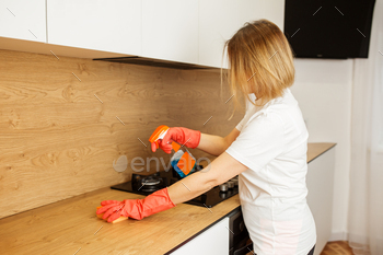Woman Cleaning Kitchen Countertop with Spray