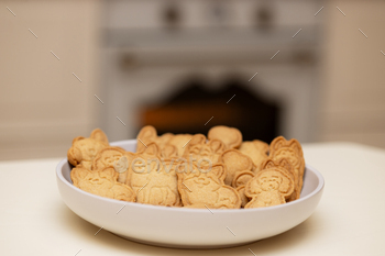 plate of cookies is a treat for dogs on the kitchen table. Cookies in the form of a dog
