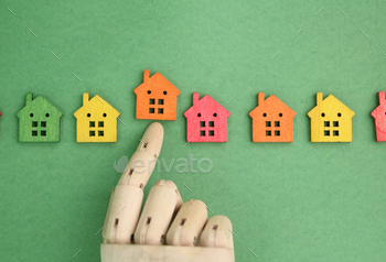 wooden hand rejects or chooses a house. the concept of choosing a house or real estate.