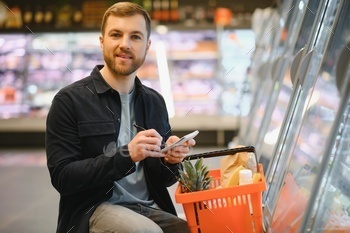 Young man shopping in grocery store. Shopping concept