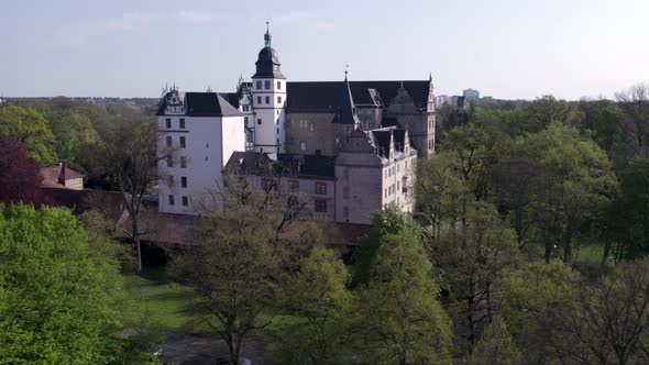 Low rotating shot of Wolfsburg castle with trees in front