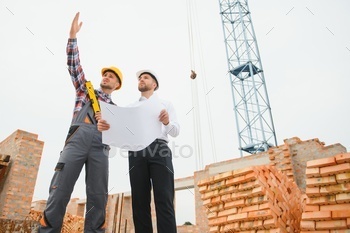 Construction engineers supervising progress of construction project