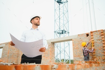 Construction concept of Engineer working at Construction Site with blue print.