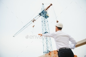 Construction concept of Engineer working at Construction Site with blue print.