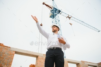 Construction concept of Engineer working at Construction Site with blue print.