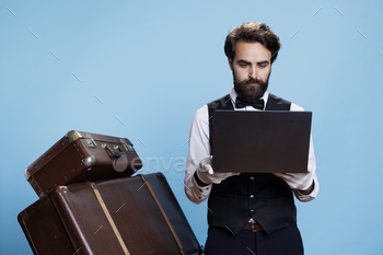 Hotel porter in suit using laptop