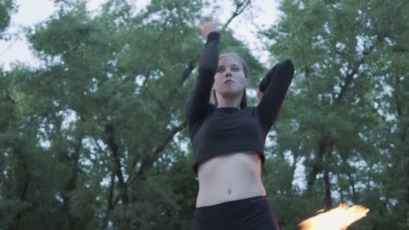 Slim Woman in Mask Dancing, Performing a Show with Fireball Standing on the Riverbank