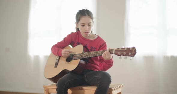 young girl playing guitar and singing