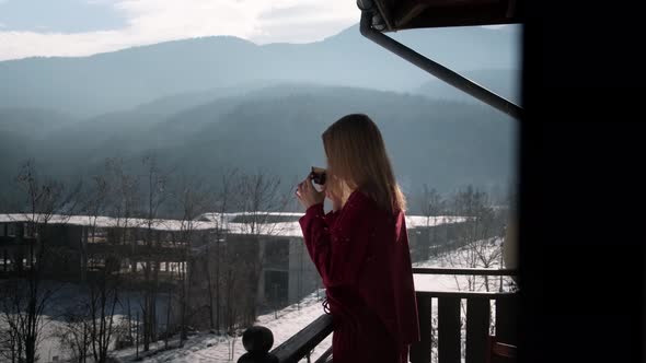 Young woman on balcony at chalet.