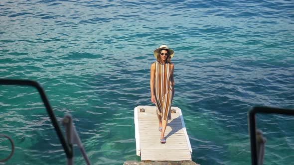 A woman traveling alone on a dock over the Mediterranean Sea in Italy, Europe