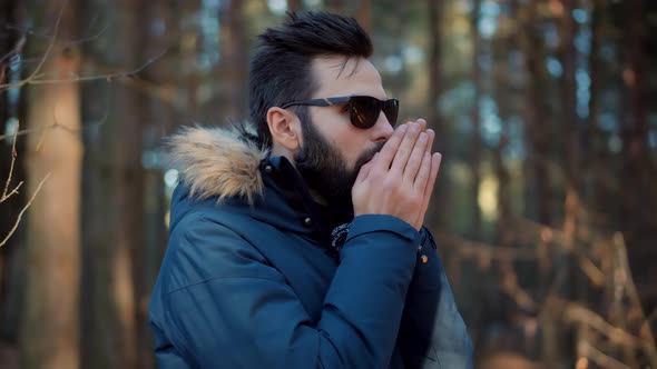 Bearded Man Warming His Cold Hands In Winter Day. Holiday Vacation Trip In Winter Forest.