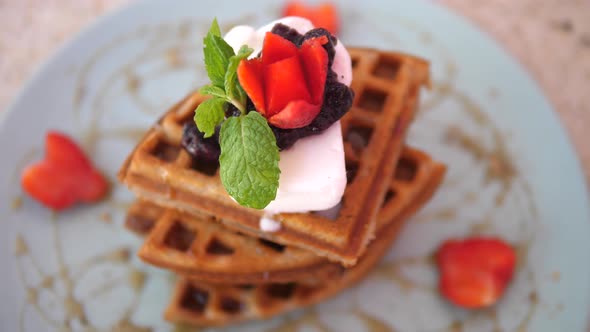 Top View of a Stack of Vegan Belgian Waffles Served with Cream and Berries