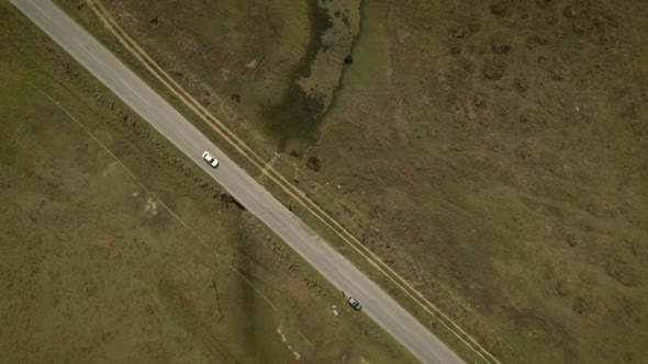 Aerial view of a car driving on road in the countryside.