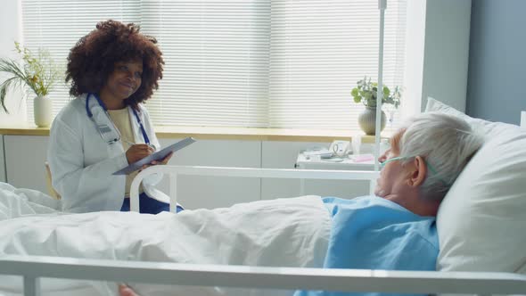 African American Female Doctor Checking on Senior Patient