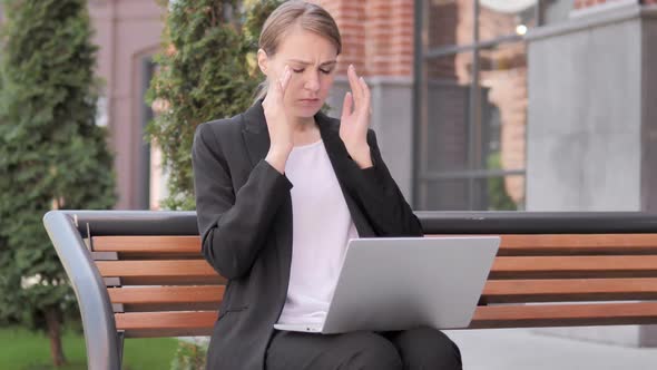 Sitting Outdoor Young Businesswoman with Headache Using Laptop