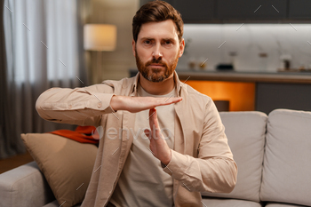 Attractive serious bearded man, translator talking with sign language, gesturing, looking at camera