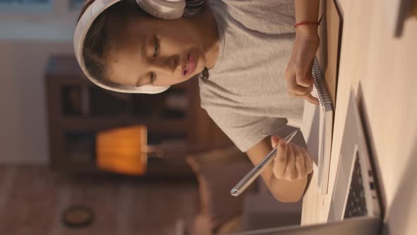 Vertical Shot of Schoolgirl Talking on Video Call with Teacher