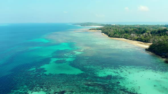 Aerial: flying over tropical beach island coral reef dreamlike turquoise caribbean sea Indonesia