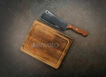 Meat cleaver and chopping board on table