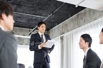 Businessmen answering questions at a meeting