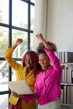 Two african woman celebrate when business goal success. achievement and business goal success
