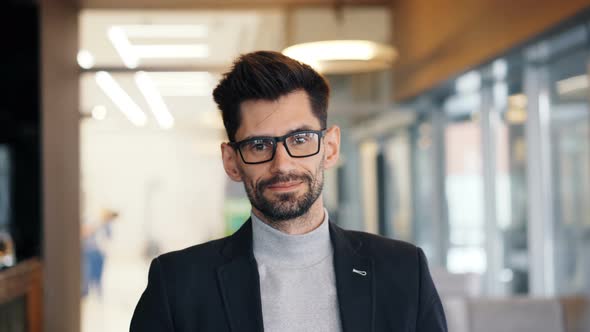 Portrait of Good-looking Mature Businessman Standing in Cafe Alone Smiling