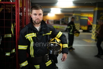 A firefighter puts on a fire uniform at the fire department