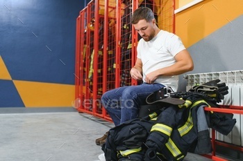 A firefighter puts on a fire uniform at the fire department