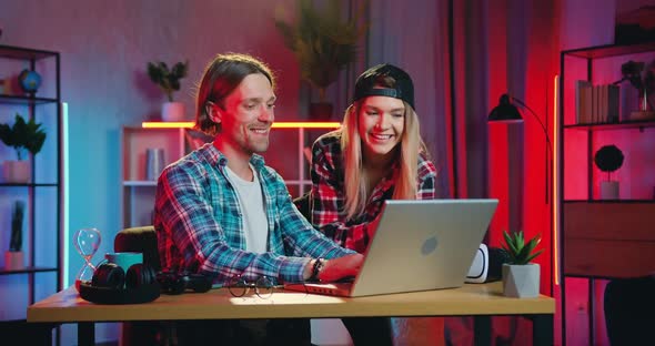 Young Couple Spending Joint Time at Home in the Evening Using Computer