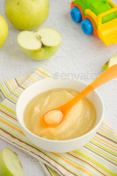 Baby food. Homemade apple puree or sauce from organic apples in a bowl with fresh apples.