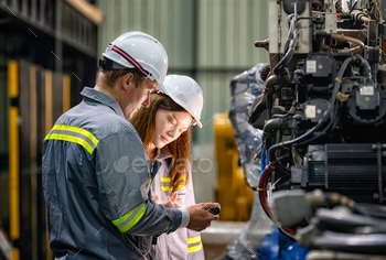 Indusrtial Robot, Engineers inspecting and check up  welding robots at factory.