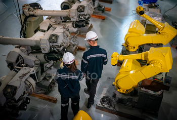 Indusrtial Robot, Engineers inspecting and check up  welding robots at factory.